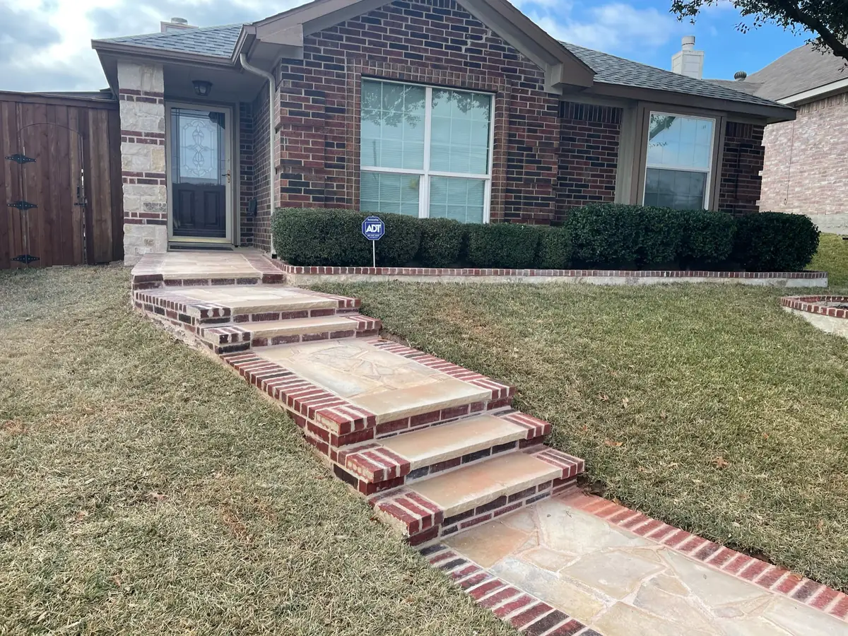 Brick-edged flagstone steps and walkway leading up to a brick home